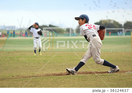 休憩時間に投球練習をしている野球少年の写真素材