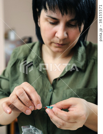 The woman does necklace. 36155571