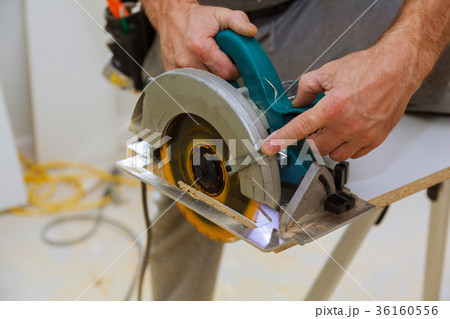 Close-up of carpenter using a circular saw to cut Close-up of carpenter using a circular saw to cut 36160556