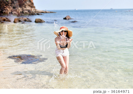 Beautiful woman wearing a swimsuit playing in the beach. Beautiful woman wearing a swimsuit playing in the beach. 36164971