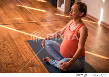 Calm impregnate lady doing yoga 36172473