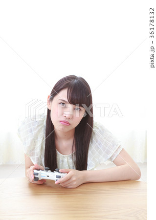 ゲームコントローラーを持つ若い女性の写真素材