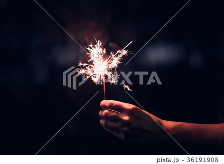 Hand holding burning Sparkler blast on a black 36191908