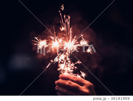 Hand holding burning Sparkler blast on a black  36191909