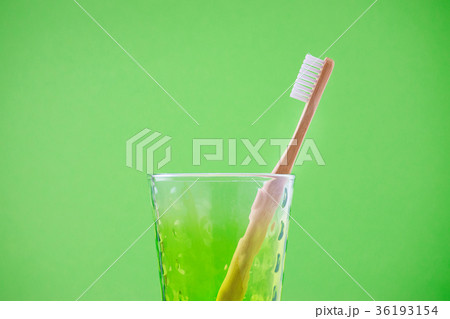alternative wooden toothbrush in a glass on green 36193154