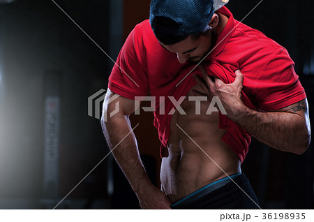 Young sports man shows relief abdominal muscles Young sports man shows relief abdominal muscles 36198935