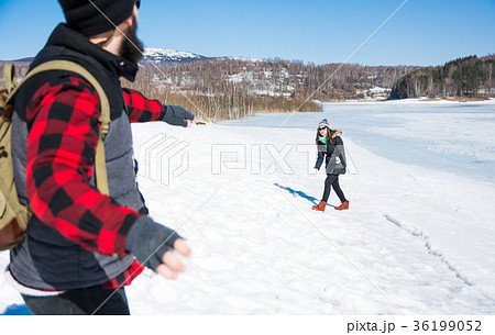 Couple having a snowball fight on a sunny day 36199052