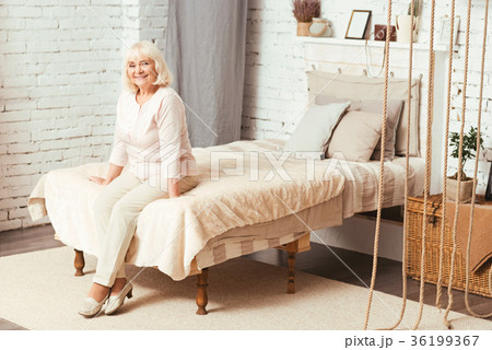 Happy aged pensioner sitting in the bedroom Happy aged pensioner sitting in the bedroom 36199367