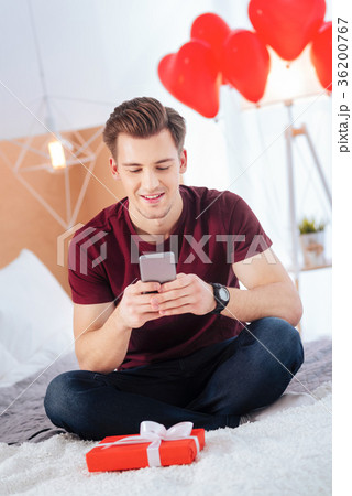 Smiling gentleman exchanging messages with 36200767