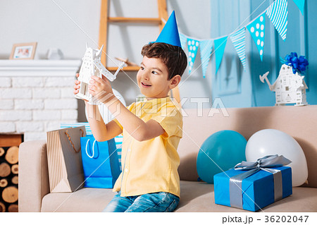Cute little boy in party hat playing with robot Cute little boy in party hat playing with robot 36202047