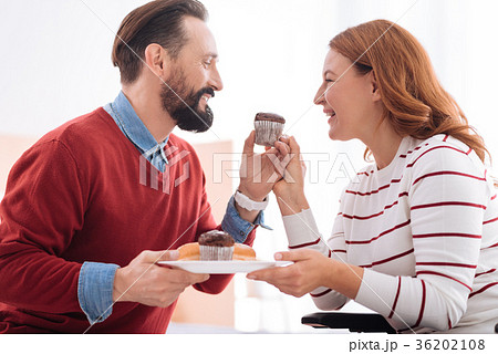Cheerful man and woman having cookies 36202108