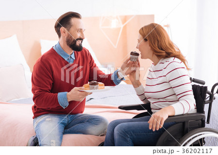 Alert man giving cookies to a paralyzed woman Alert man giving cookies to a paralyzed woman 36202117