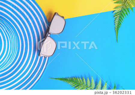 Blue hat and sunglasses on colorful paper Blue hat and sunglasses on colorful paper 36202331