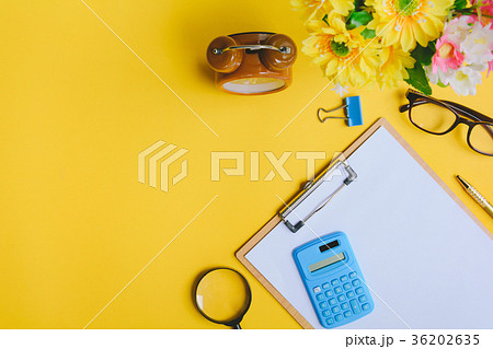 Office equipment on a yellow and golden paper desk 36202635