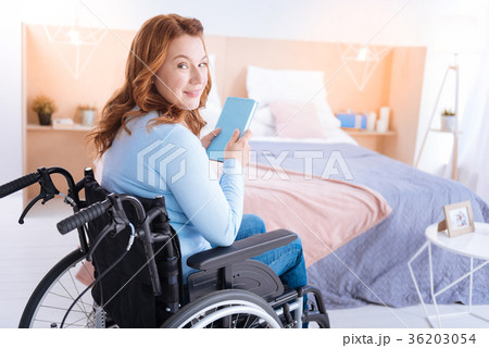 Attractive smiling disabled woman holding a book Attractive smiling disabled woman holding a book 36203054