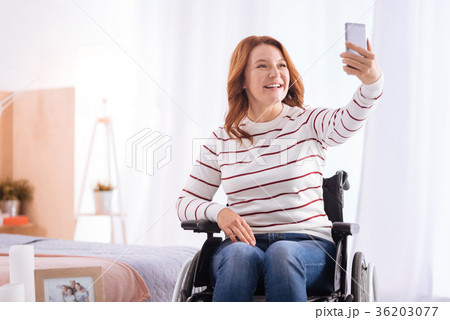 Disabled smiling woman taking photos 36203077