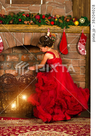 Little winter Princess warms at burning fireplace 36204028