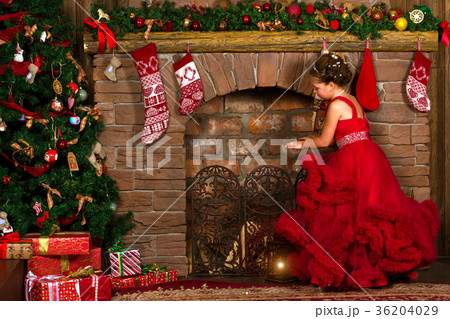 Little winter Princess warms at burning fireplace 36204029