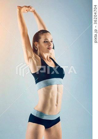 Cheerful fitness lady smiling while warming up her Cheerful fitness lady smiling while warming up her 36204704