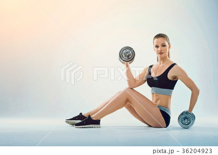 Fit cheerful fitness girl sitting on floor with 36204923