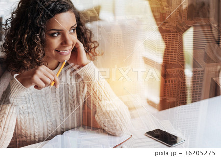 Cheerful young woman sitting and smiling while 36205275