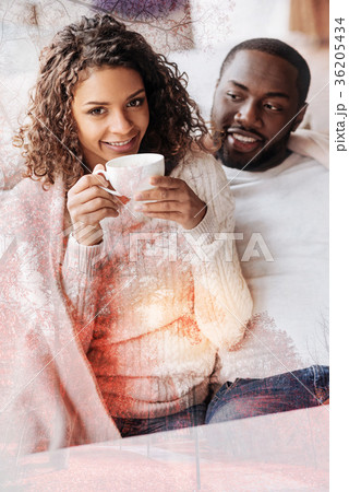 Waist up of delighted couple sitting close to each 36205434