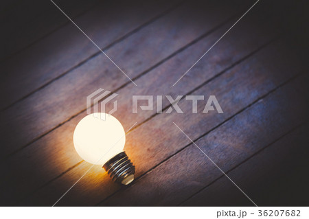 Light on bulb on wooden background. 36207682