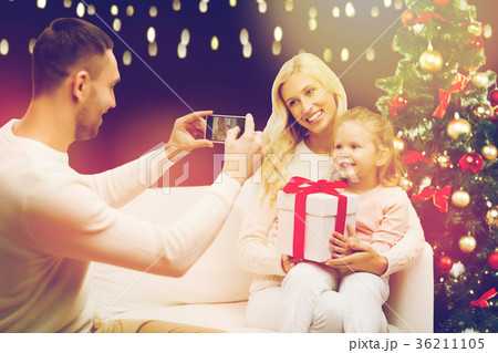 man photographing his family with christmas gift man photographing his family with christmas gift 36211105