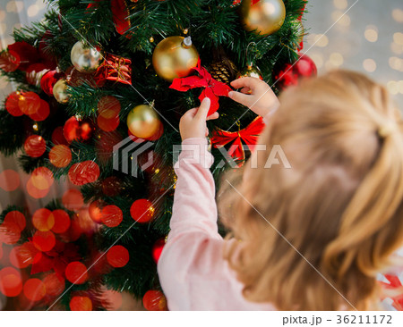 close up of little girl decorating christmas tree 36211172