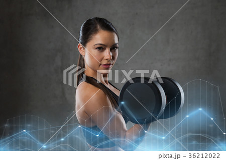 young woman flexing muscles with dumbbells in gym young woman flexing muscles with dumbbells in gym 36212022
