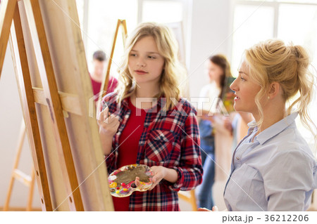 artists discussing painting on easel at art school artists discussing painting on easel at art school 36212206