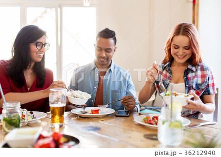 happy friends eating at restaurant happy friends eating at restaurant 36212940