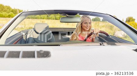 happy young woman driving convertible car 36213536