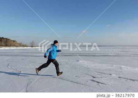 Man running across the ice of a frozen river Man running across the ice of a frozen river 36217970