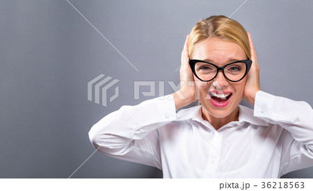 Young woman plugging her ears 36218563