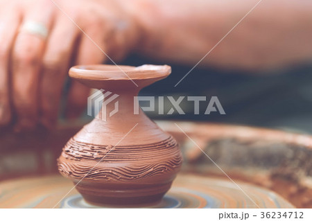 Potter making ceramic pot on the pottery wheel 36234712
