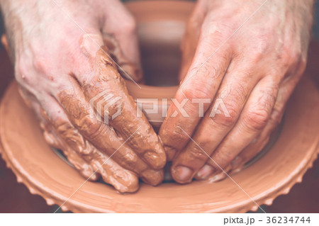 Potter making ceramic pot on the pottery wheel 36234744