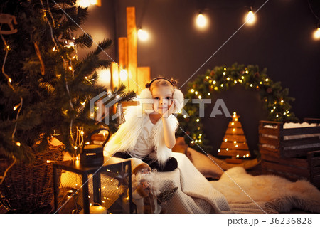 Cute little girl in fur earmuffs sitting near Cute little girl in fur earmuffs sitting near 36236828