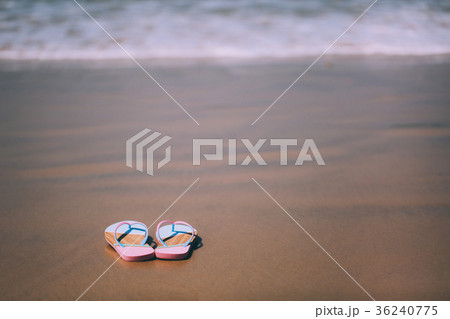 Trendy slippers on the sandy beach. Trendy slippers on the sandy beach. 36240775