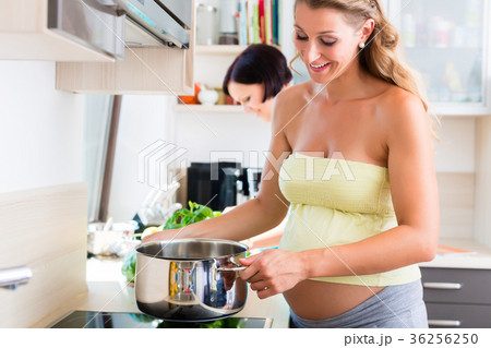 Pregnant woman cooking with best friend Pregnant woman cooking with best friend 36256250