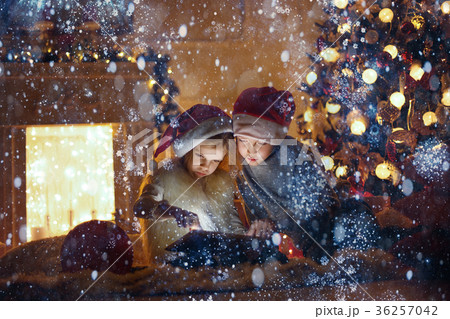 Amazed children using tablet near Christmas tree Amazed children using tablet near Christmas tree 36257042
