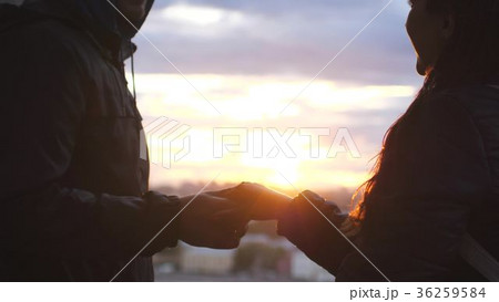 Couple in love holding hands over the city sunset 36259584