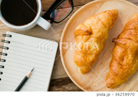 Croissants coffee notebook eyeglasses pencil Croissants coffee notebook eyeglasses pencil 36259970