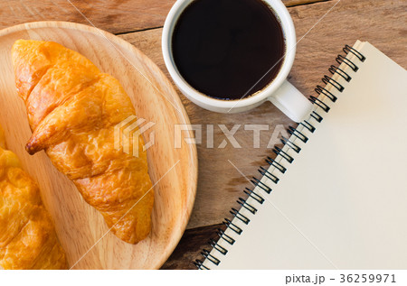 Croissants coffee notebook on the wooden table 36259971