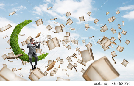 Handsome violinist play his melody and books flying around 36268050