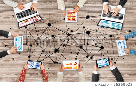 Top view of businesspeople sitting at table and using gadgets Top view of businesspeople sitting at table and using gadgets 36269022