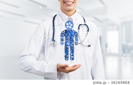 Woman doctor palm showing figure made of gear mechanism as symbol for self organization 36269868