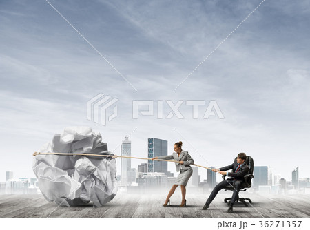 Businesspeople pulling with effort big crumpled ball of paper as creativity sign 36271357