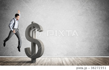 Determined banker man in empty concrete room breaking dollar figure Determined banker man in empty concrete room breaking dollar figure 36272351