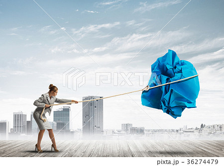 Woman pulling with effort big crumpled ball of paper as creativity sign Woman pulling with effort big crumpled ball of paper as creativity sign 36274479